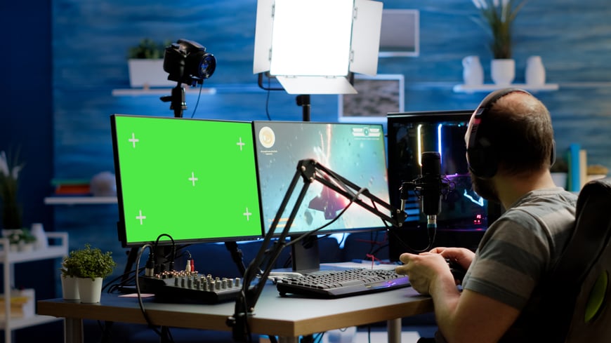 gamer-streaming-online-videogames-professional-powerful-computer-with-green-screen-mock-up-chroma-key-display-streamer-playing-space-shooter-game-isolated-desktop-holding-wireles-controller